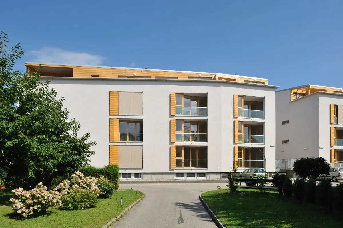 Večstanovanjska stavba z lesenimi polkni in vrtom
